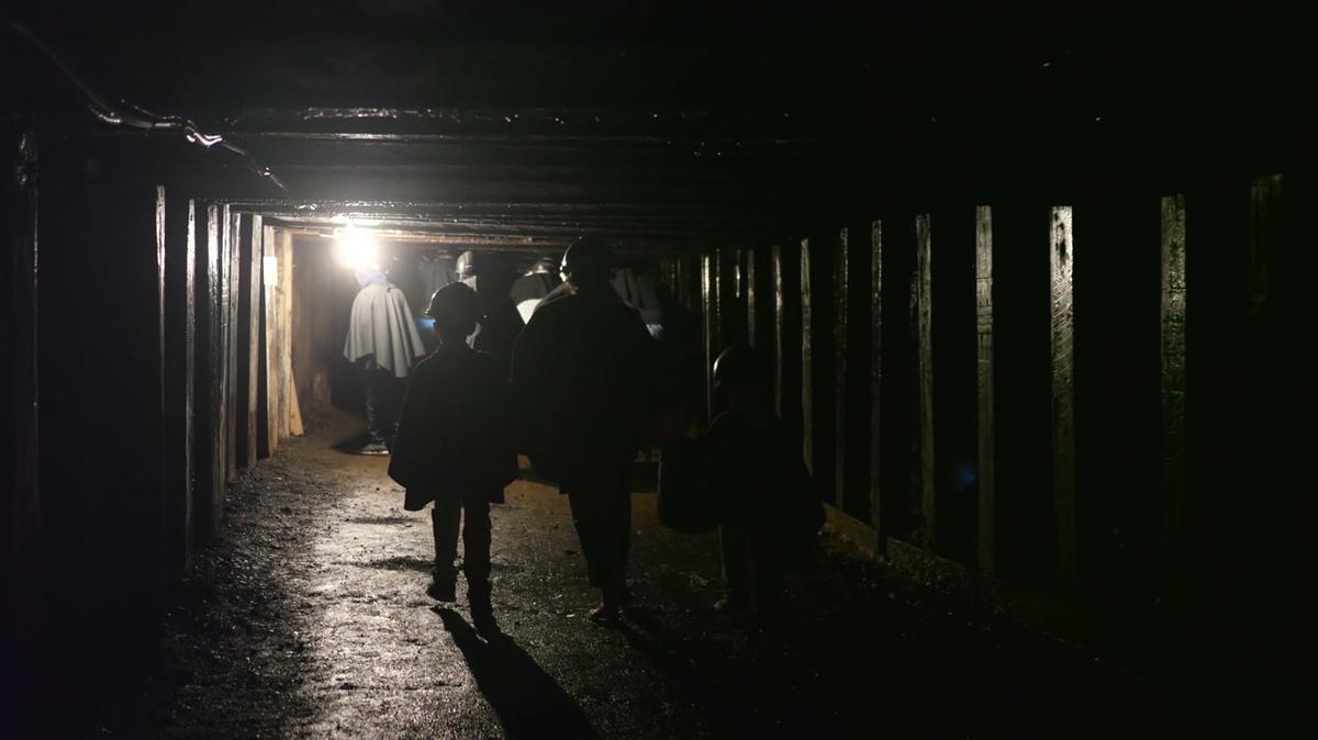 young family walking through dark coal mine in glace bay nova scotia