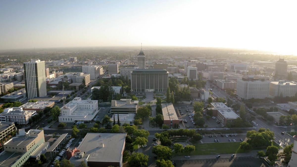 City buildings and traffic on roads at sunset aerial